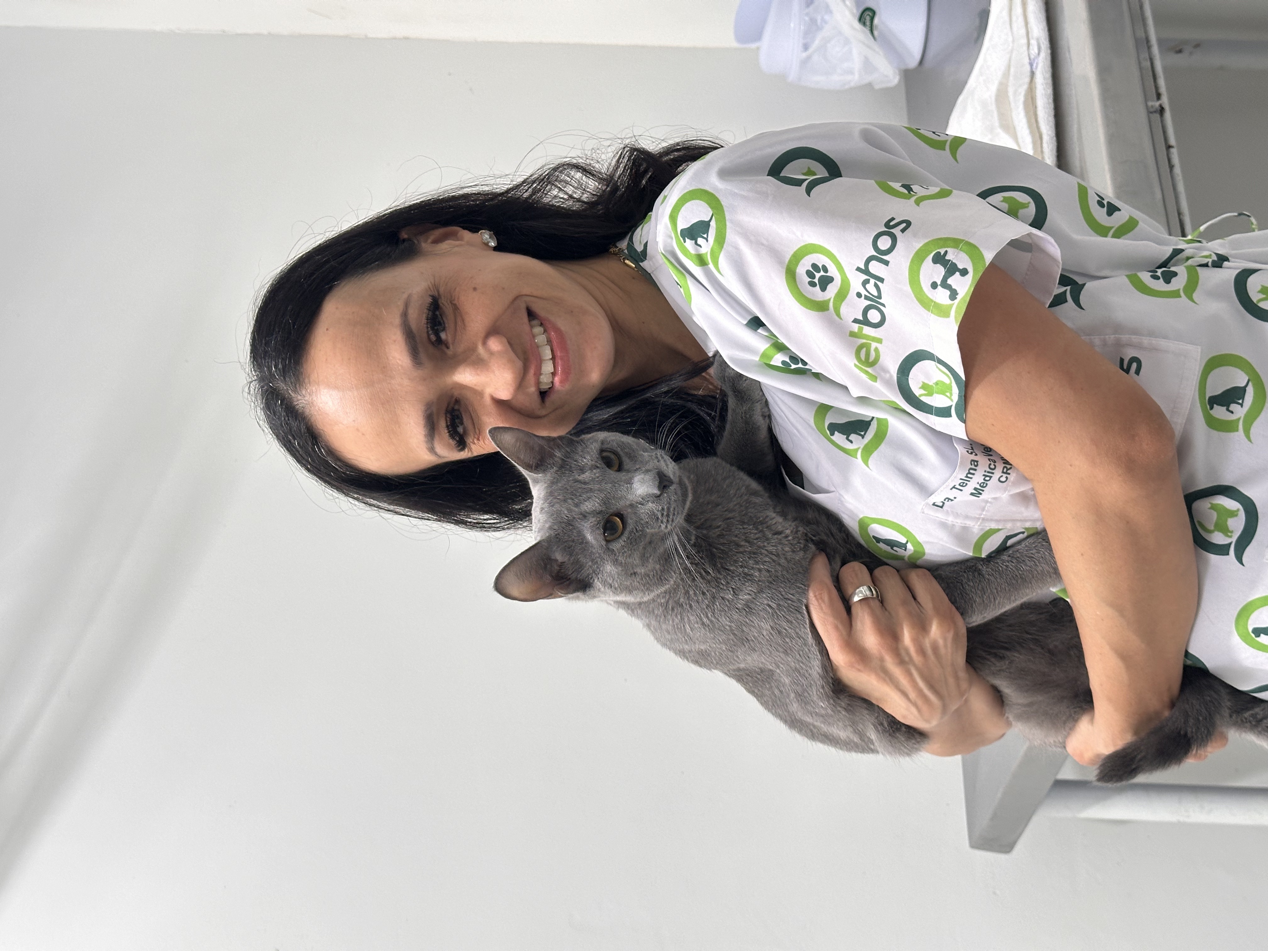 Dra. Telma Santos Lima da Vetbichos com gato cinza, demonstrando cuidado e experiência